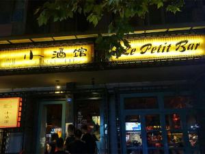 成都市にある7Days Premium Chengdu Yulin South Street Branchの夜の外に立つ人々