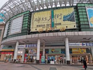 a shopping mall with a large sign on it at 7Days Premium Dongguan Dongcheng Subway Station in Dongguan