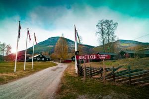 a dirt road leading to a village with flags at Kirketeigen Camping in Kvam +1 photo