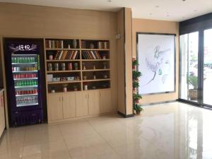 um quarto com uma estante de livros e um grande ecrã em 7Days Premium Huai'an Hexia Ancient Town Zhou Enlai Former Residence Branch em Hexia
