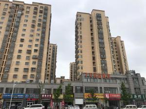 Hexiaにある7Days Premium Huai'an Hexia Ancient Town Zhou Enlai Former Residence Branchの車を持つ都市の高層ビル2棟