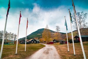 a dirt road with flags in front of a mountain at Kirketeigen Camping in Kvam