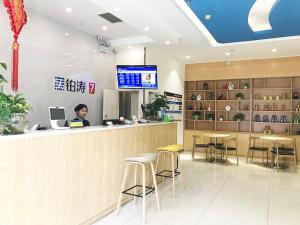 a man sitting at a bar in a restaurant at 7Days Premium Chengdu Pi County Xiqu Avenue Branch in Chengdu