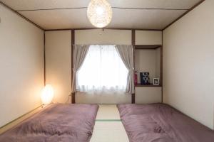 sypialnia z dużym łóżkiem przed oknem w obiekcie Mibusanjo Guesthouse w mieście Kioto