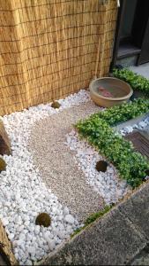 ogród z kamieniami i miską roślin w obiekcie Mibusanjo Guesthouse w mieście Kioto