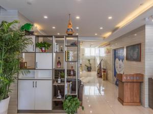 Xingtaiにある7 Days Premium Xingtai Ruihe City Branchの白いキャビネットと植物のあるロビー