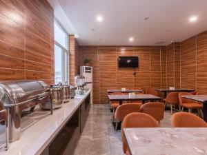 Xingtaiにある7 Days Premium Xingtai Ruihe City Branchの木製の壁とテーブルと椅子が備わるレストラン