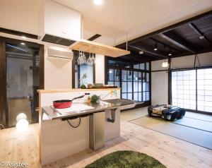 una cucina con bancone in una stanza con finestre di Sanjyomisasagi Umenotoan a Kyoto