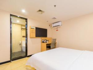 Un pat sau paturi într-o cameră la 7 Days Premium Sanya Bay Haiyue Plaza Foreign Trade Road Food Street Branch