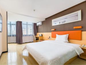 une chambre d'hôtel avec un grand lit et un bureau dans l'établissement 7 Days Premium Sanya Bay Haiyue Plaza Foreign Trade Road Food Street Branch, à Sanya
