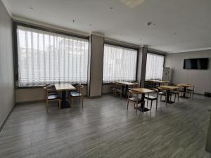 a classroom with tables and chairs in a room with windows at 7Days Premium Jiyuan Tiantai Road Xinyao City Square Branch in Jiyuan