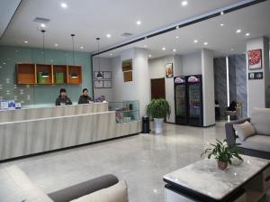 a lobby with two people standing at a counter at 7Days Premium Zhumadian Tianzhongshan Avenue Branch in Zhumadian
