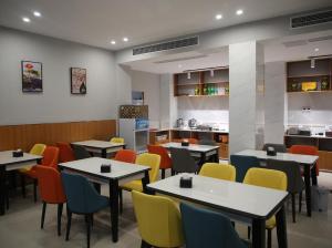 una sala da pranzo con tavoli e sedie colorate di 7Days Premium Zhumadian Tianzhongshan Avenue Branch a Zhumadian