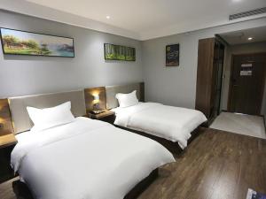 Zhumadianにある7Days Premium Zhumadian Tianzhongshan Avenue Branchの白いシーツが敷かれたホテルの部屋にベッドが2つある +8枚の写真