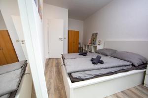 1 dormitorio con 1 cama en una habitación blanca en Ruhiges City Apartment "Altbauperle" mit Charme und 2 Schlafzimmern, en Erfurt