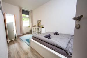 1 dormitorio con cama y ventana grande en Ruhiges City Apartment "Altbauperle" mit Charme und 2 Schlafzimmern, en Erfurt