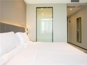 A bed or beds in a room at 7Days Premium Mianyang Donghu Park Branch