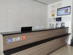 a reception desk with a laptop on top of it at 7Days Premium Shangdi Tiyu University Branch in Beijing