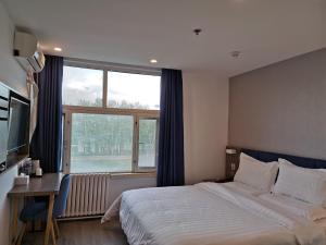 a bedroom with a large bed and a large window at 7Days Premium Shangdi Tiyu University Branch in Beijing