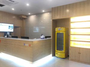 a lobby with a yellow machine next to a counter at 7Days Premium Huaian Zhou Enlai Memorial Hall Yuanhuai East Road Branch in Hexia