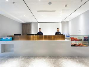 two people sitting at a desk in a conference room at 7Days Premium Chongqing North Train Station North Square Center Branch in Chongqing