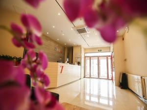 un vestíbulo con flores rosas en primer plano y un mostrador en 7 Days Premium, Dongying Xisan Road Ginza Branch, en Dongying
