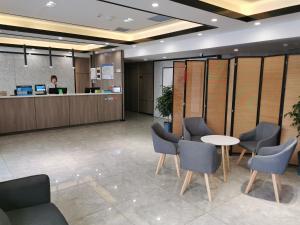 a lobby with a desk and chairs and a man in the background at 7Days Premium Tianjin Ancient Culture Street Tianjin Eye Branch in Tianjin