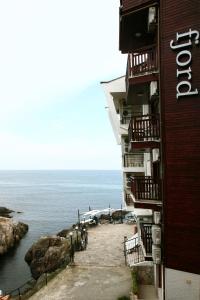 a building with balconies next to a body of water at Fjord B&B in Sozopol