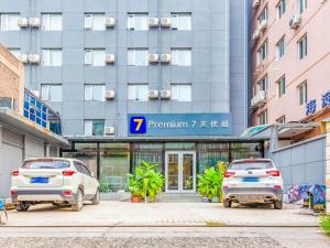 dois carros estacionados em frente a um edifício em 7Days Premium Beijing Zhongguancun Renmin University Suzhou Street Subway Station Branch em Pequim
