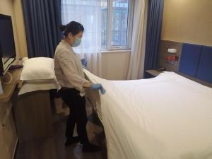 a woman in a hospital room making a bed at 7Days Premium Beijing Zhongguancun Renmin University Suzhou Street Subway Station Branch in Beijing +15 photos