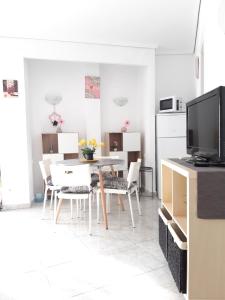 a living room with a table and chairs and a television at Apartamento Retiro in Denia