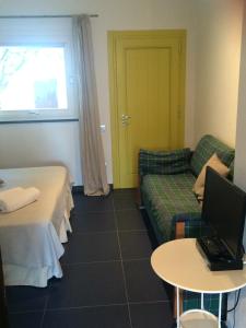une chambre d'hôtel avec un canapé et un ordinateur portable sur une table dans l'établissement Il Gabbiano Relais in Stromboli, à Stromboli