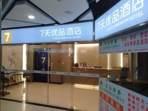 a glass door in a building with signs on it at 7Days Premium Shenzhen Zhuzilin Subway Station in Shenzhen