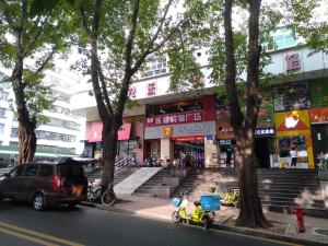 a car parked on the street in front of a building at 7Days Premium Shenzhen Zhuzilin Subway Station in Shenzhen