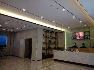 a hotel lobby with a reception desk and a mirror at 7Days Premium Jinzhou Railway Station Branch in Jinzhou