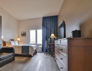 a hotel room with a bed and a flat screen tv at Comfort Inn & Suites in Saint-Jérôme