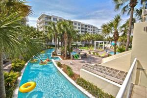 une piscine dans un complexe avec des palmiers et un complexe dans l'établissement Destin West Beach Resort #609-1Br/2Ba-Sleeps 6, à Fort Walton Beach