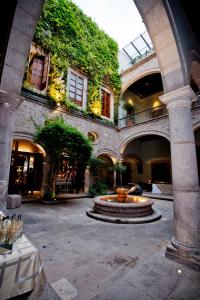a courtyard with a fountain in the middle of a building at Casa Grande Hotel Boutique in Morelia