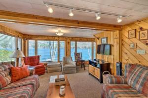 a living room with couches and a flat screen tv at Waterfront Home on Lake George with Boat Dock! in Queensbury