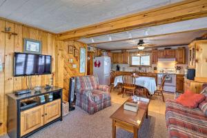 a living room with a table and a kitchen at Waterfront Home on Lake George with Boat Dock! in Queensbury