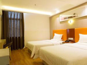 um quarto de hotel com duas camas e uma janela em 7Days Inn Fuyang Railway Station em Fuyang