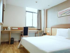 A bed or beds in a room at 7Days Inn Haikou Nansha Road City square