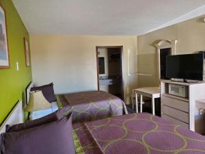 a hotel room with two beds and a flat screen tv at Lodge USA Motel in Guymon