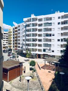 a large white apartment building with a parking lot at Casa da Praia in Armação de Pêra