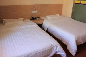 Postel nebo postele na pokoji v ubytování 7Days Inn Qidong Lvsigang