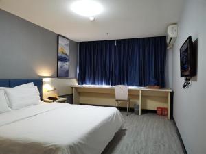 a hotel room with a bed and a desk and a window at 7Days Inn Xi'an North Street Subway Station Lianhu Park in Xi'an
