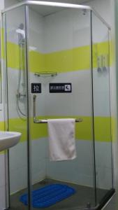 a bathroom with a shower with a sink and a towel at 7Days Inn Lanzhou West Railway Station in Lanzhou