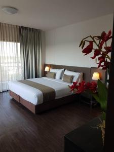 a bedroom with a large bed and a large window at Coco View Hotel in Samut Songkhram