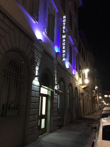 un edificio con luces azules y moradas en una calle en Hotel Magenta, en Florencia