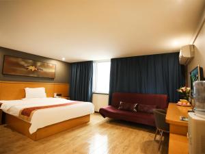 a hotel room with a bed and a couch at 7Days Inn Xuzhou Xinyi Shifu Road in Xinyi
